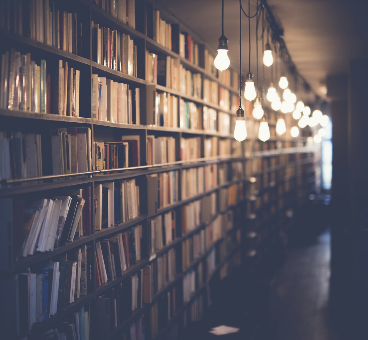 Bound newspaper volumes stacked on a shelf with handwritten spine labels